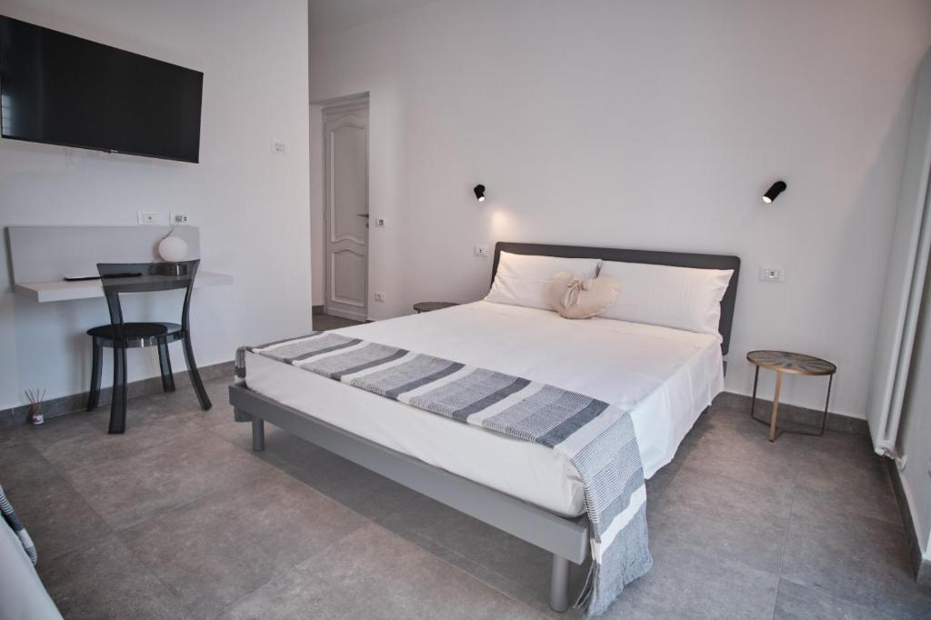 - une chambre avec un grand lit blanc et une table dans l'établissement Casa Maluna, à La Spezia