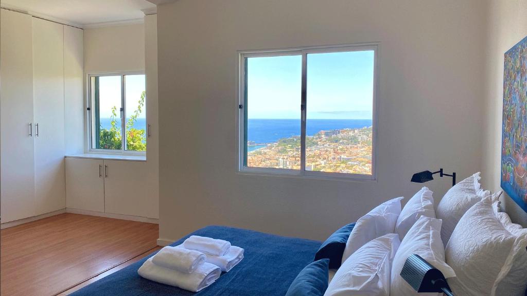 1 dormitorio con 1 cama con 2 toallas en Casa ideal para famílias com vista mar desafogada en Funchal