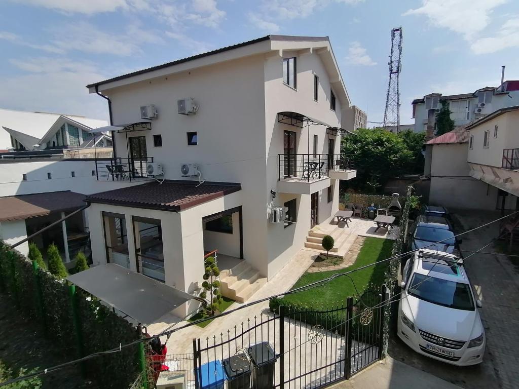 a white car parked in front of a white house at Casa di Sonia in Eforie Nord