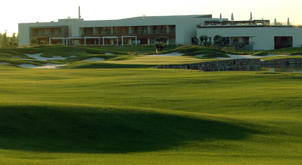 a golf course with a building and a green at Sercotel El Encin Golf in Alcalá de Henares