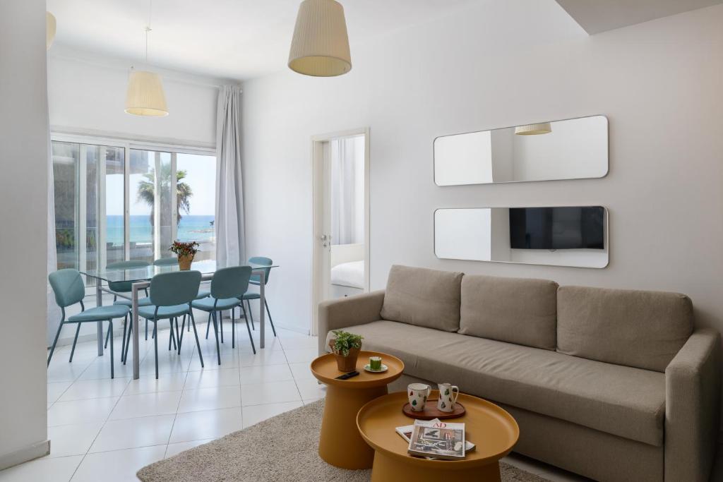 uma sala de estar com um sofá e uma mesa em Sea View 2 bedroom apartment with Bomb Shelter em Tel Aviv