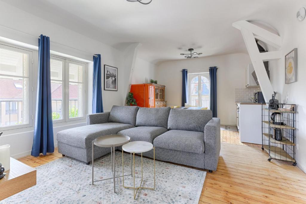 uma sala de estar com um sofá cinzento e duas mesas em Appartements de l'Abbaye - A 10 minutes de Disneyland em Lagny