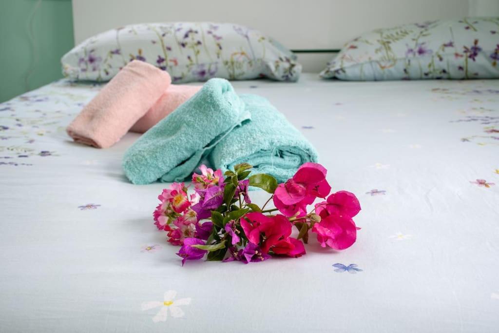 a pile of towels and flowers on a bed at Appartamento Sogno Marino in Portoferraio