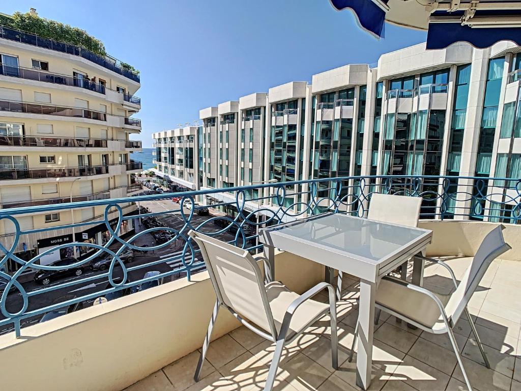 a balcony with a table and chairs and buildings at Appartements Medicis in Cannes