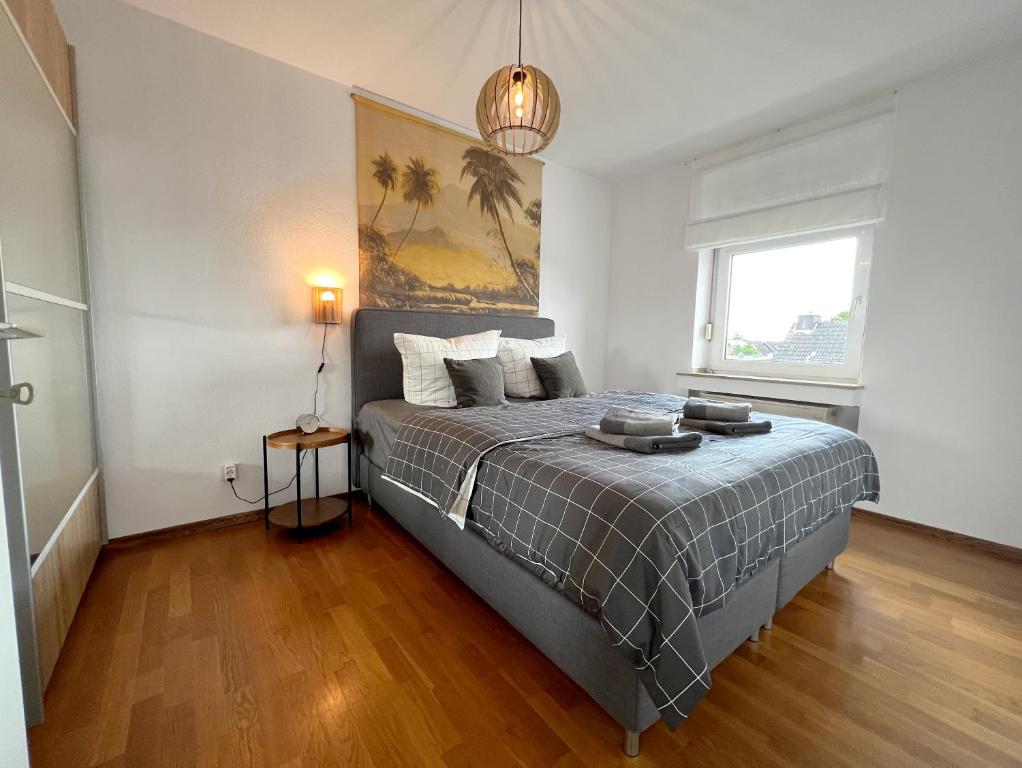 een slaapkamer met een bed en een groot raam bij Beautiful 2-room apartment with balkony in Willich in Willich