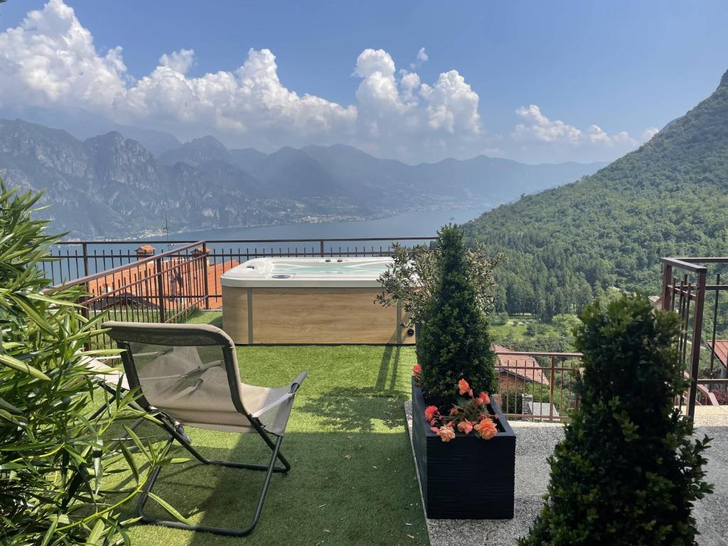 a chair and a bath tub on a balcony with mountains at IseoLakeRental - Casa Il Nido in Fonteno
