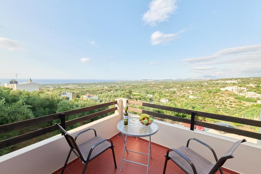 Agia Triada的住宿－Exclusive Villa - Amazing View & Private Pool，设有一个配有桌椅并享有美景的阳台。
