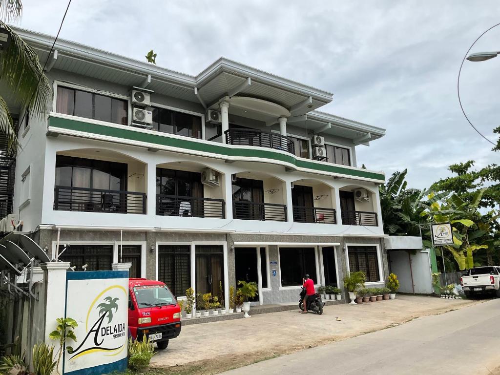 a man is standing in front of a building at Adelaida Pensionne Hotel in Bantayan Island