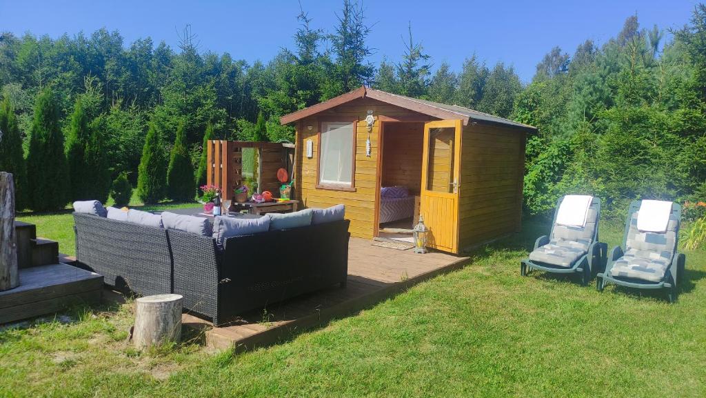 Nõva的住宿－Sillaotsa Talu，院子内带两把椅子的小小屋