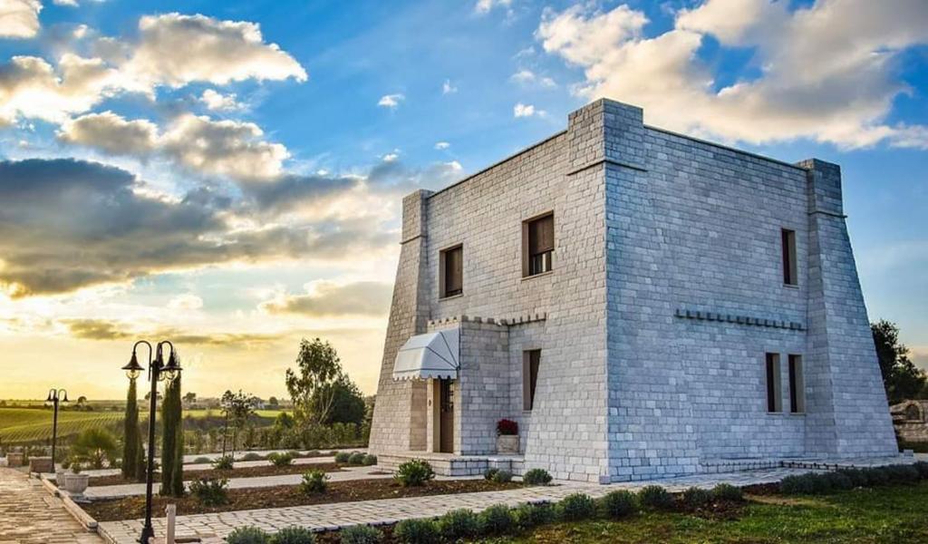 a white brick building with a cloudy sky at Albadido in Campomarino