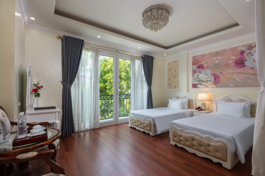 a bedroom with two beds and a large window at My Moon Hotel Hanoi in Hanoi