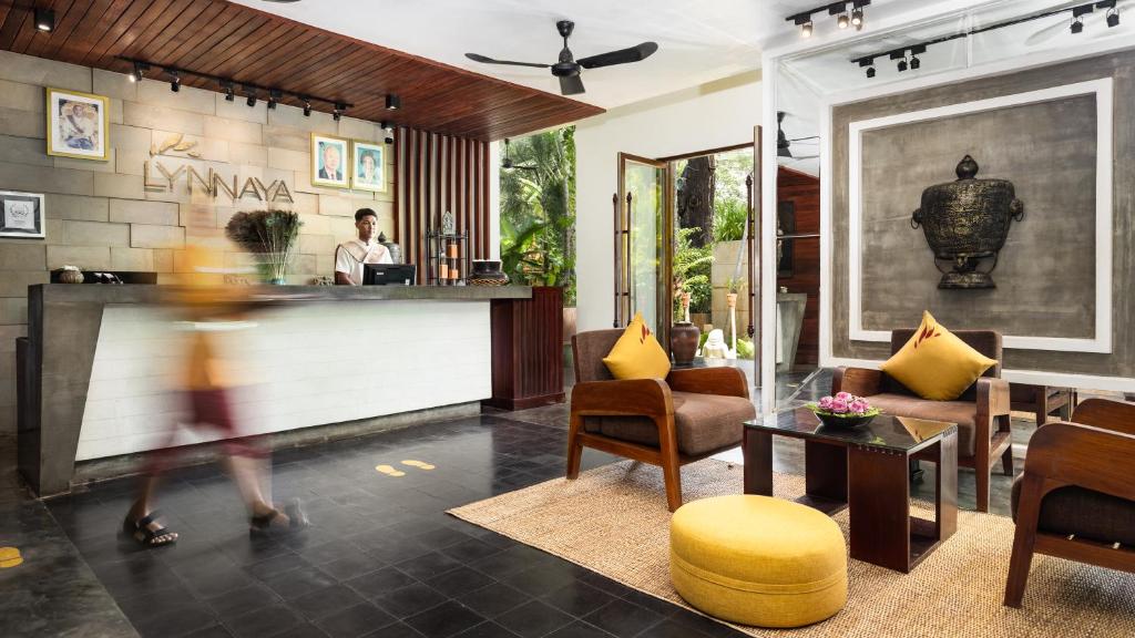 a woman walking through a lobby of a hotel at Lynnaya Urban River Resort in Siem Reap