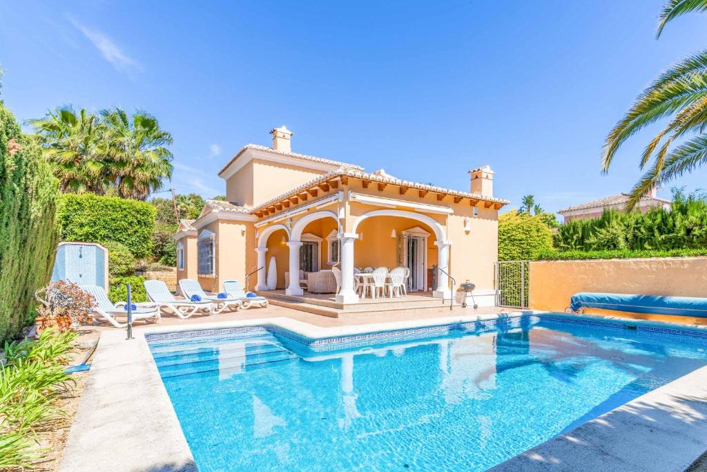 a villa with a swimming pool in front of a house at Villa Ambar Tur in Calpe