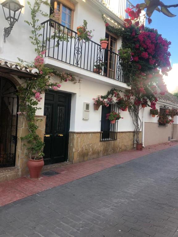 a building with flowers on the side of it at Casa centro old town in Estepona