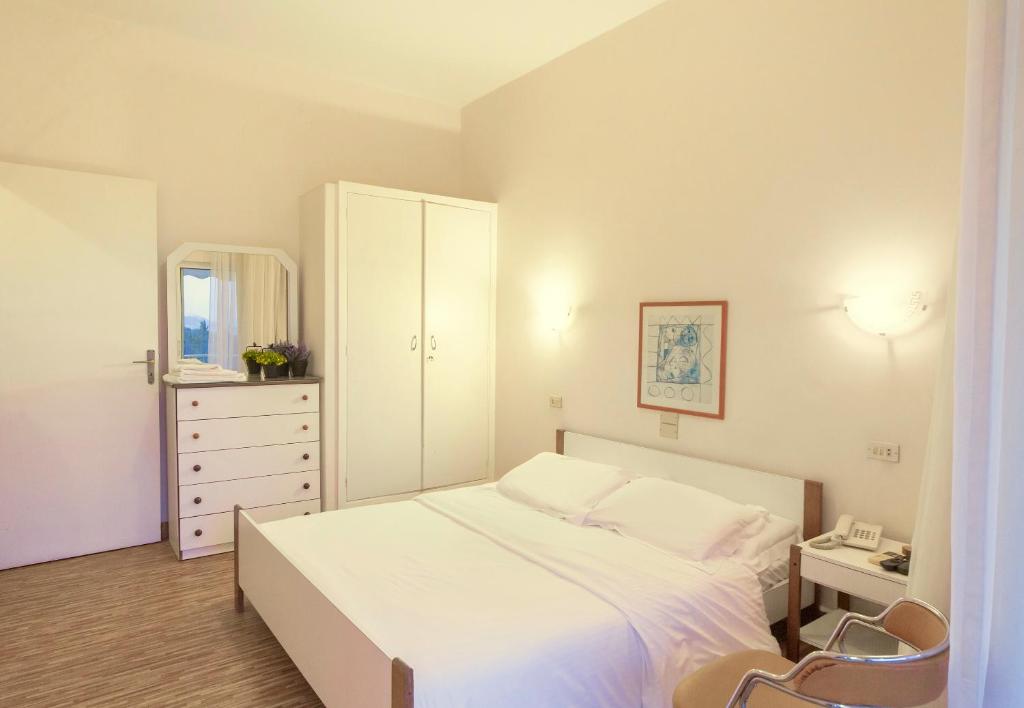 ein Schlafzimmer mit einem weißen Bett und einer weißen Kommode in der Unterkunft Merry Land Hotel in Bharsaf