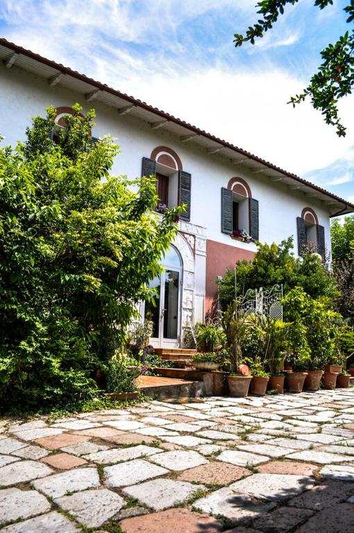 Biały dom z roślinami przed nim w obiekcie Bed & Breakfast Il Giardino w mieście Baricella