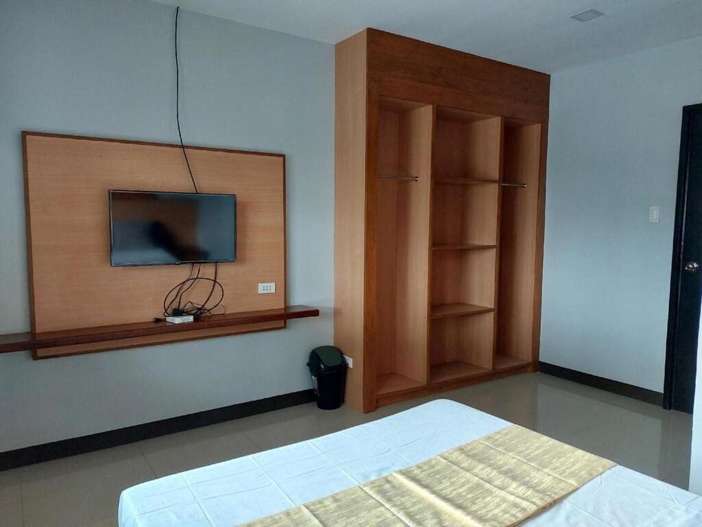 um quarto com uma cama e uma televisão na parede em Villa Tomasa 2, Panglao em Panglao