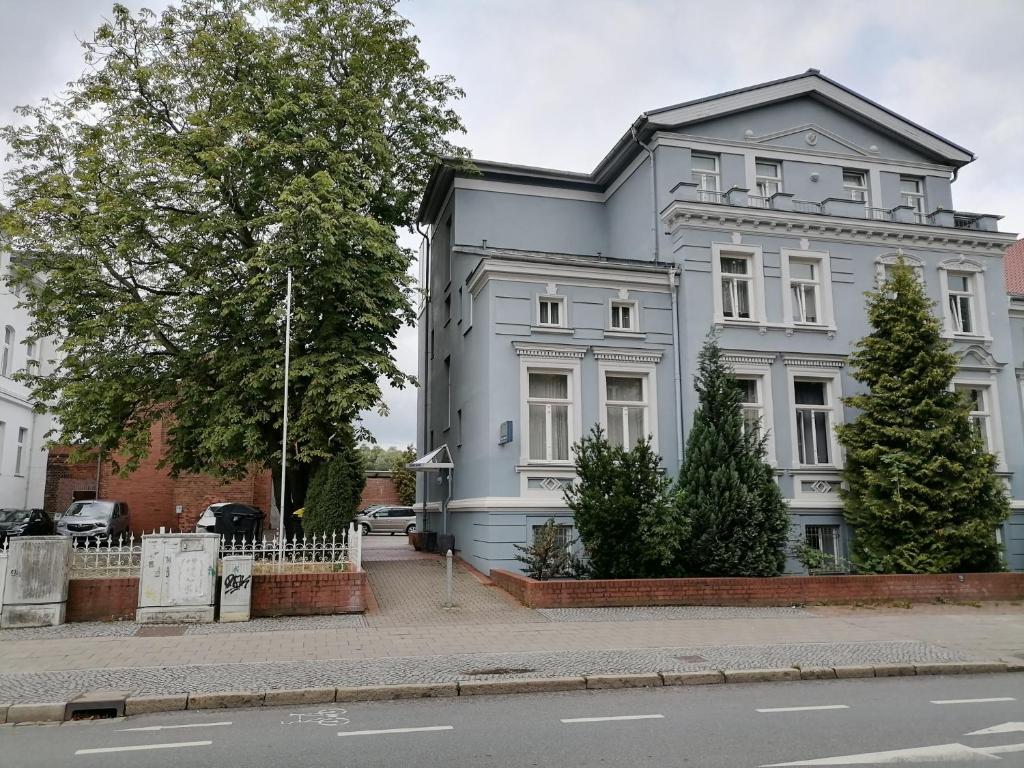 un grand bâtiment blanc sur le côté d'une rue dans l'établissement Appartement-Hotel Rostock, à Rostock
