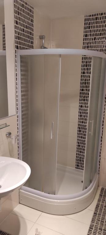 eine Glasdusche im Bad mit Waschbecken in der Unterkunft Hotel & Rooms Lombrelle in Mostar