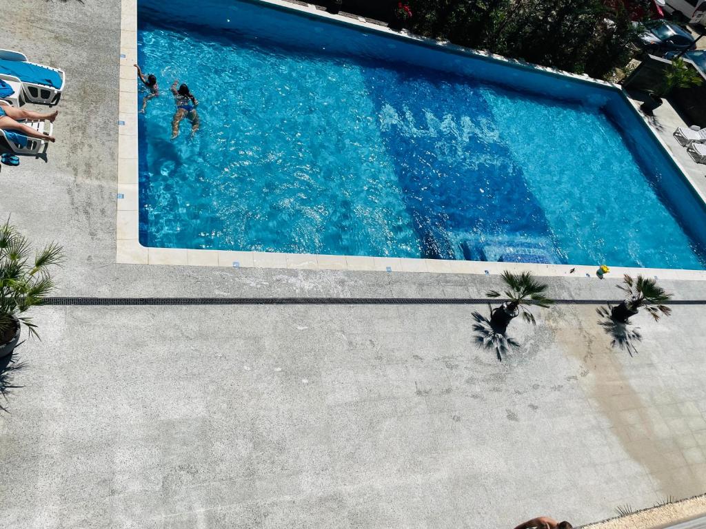 an overhead view of a swimming pool with two people in it at DXN Luxury Studio in Năvodari