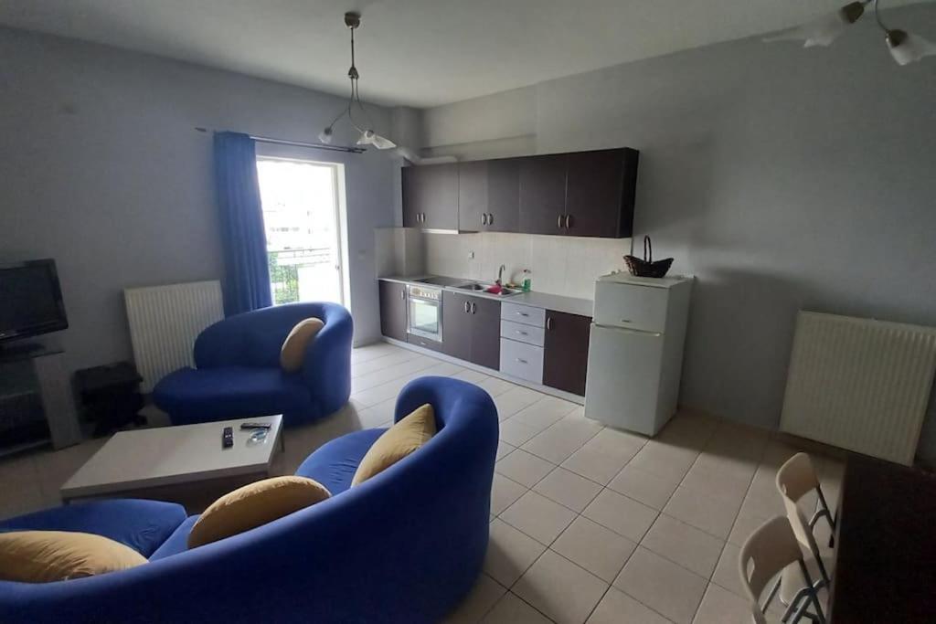 un soggiorno con sedie blu e una cucina di Gerard Luxury apartment a Patra
