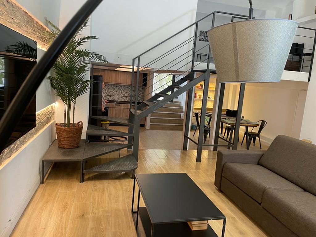 uma sala de estar com um sofá e uma escada em Loft Marconi 34 em Soverato Marina