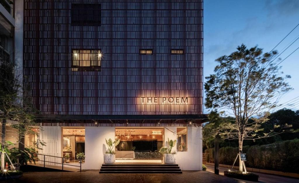 a building with a sign that reads the program at The Poem Hotel in Mae Pim