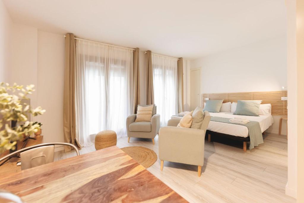 a bedroom with a bed and a couch and a chair at Bravissimo Plaça Catalunya 1-2, Studio apartment in Girona