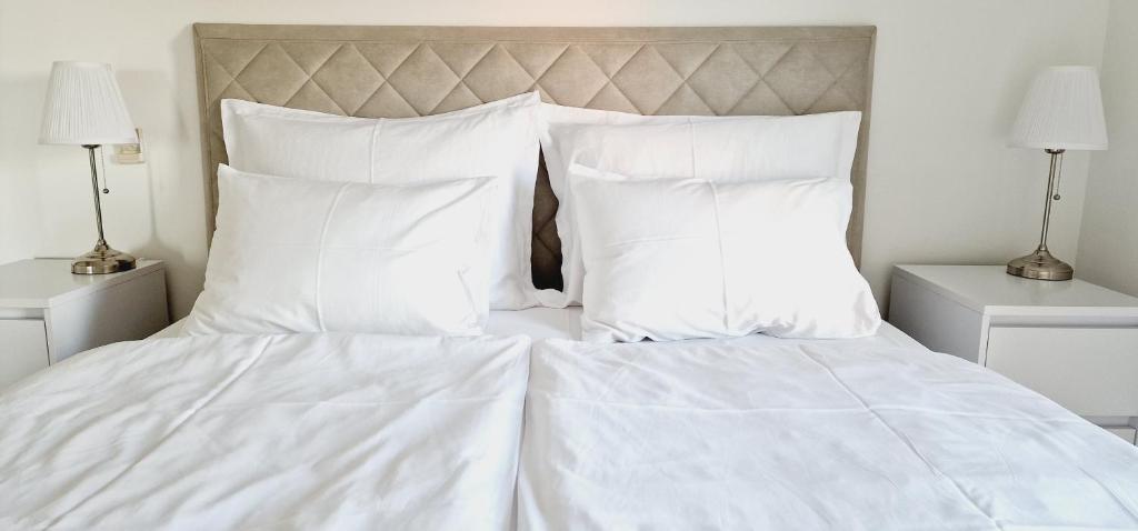 - un lit blanc avec des draps et des oreillers blancs dans l'établissement Moonlight apartment, à Matulji