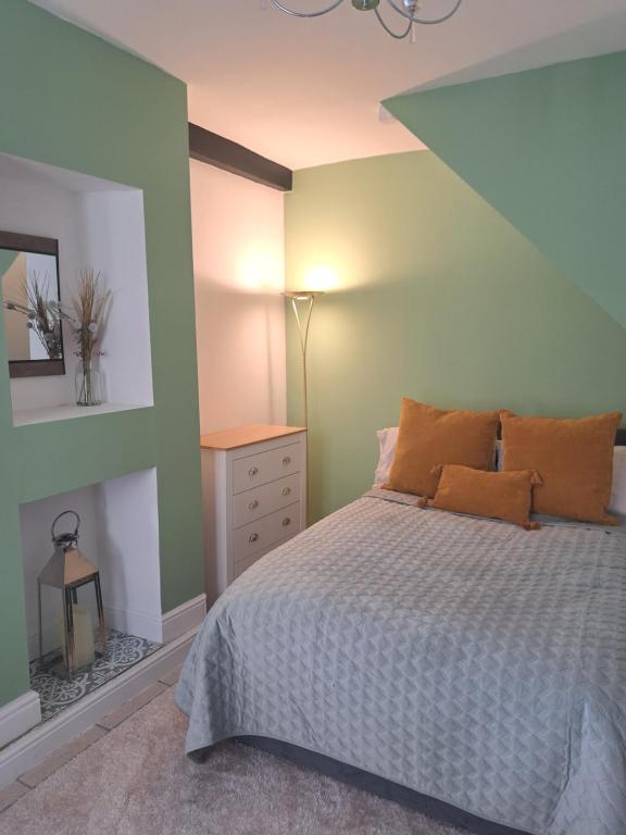 a bedroom with a bed and a green wall at The Snug in Cockermouth