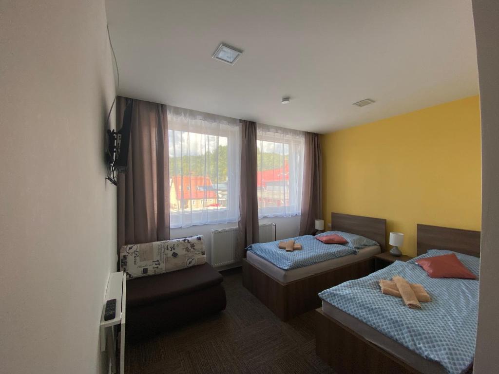 a bedroom with two beds and a window at Penzion Teplanka in Považská Bystrica