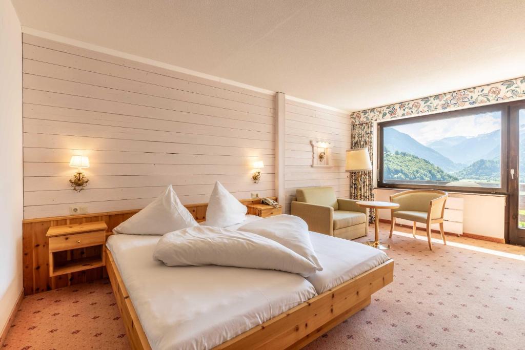 pokój hotelowy z łóżkiem i dużym oknem w obiekcie keyone rooms Montafon w mieście Schruns