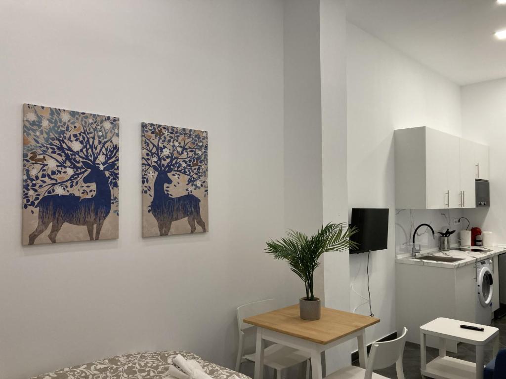 three paintings of deer on a wall in a kitchen at Ensanche Apartments in Madrid