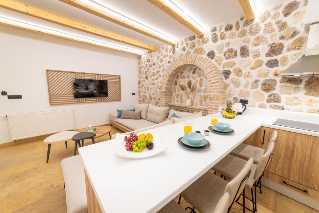 cocina y sala de estar con mesa blanca y sillas en Domus Inn Luxury Apartments, en Parga