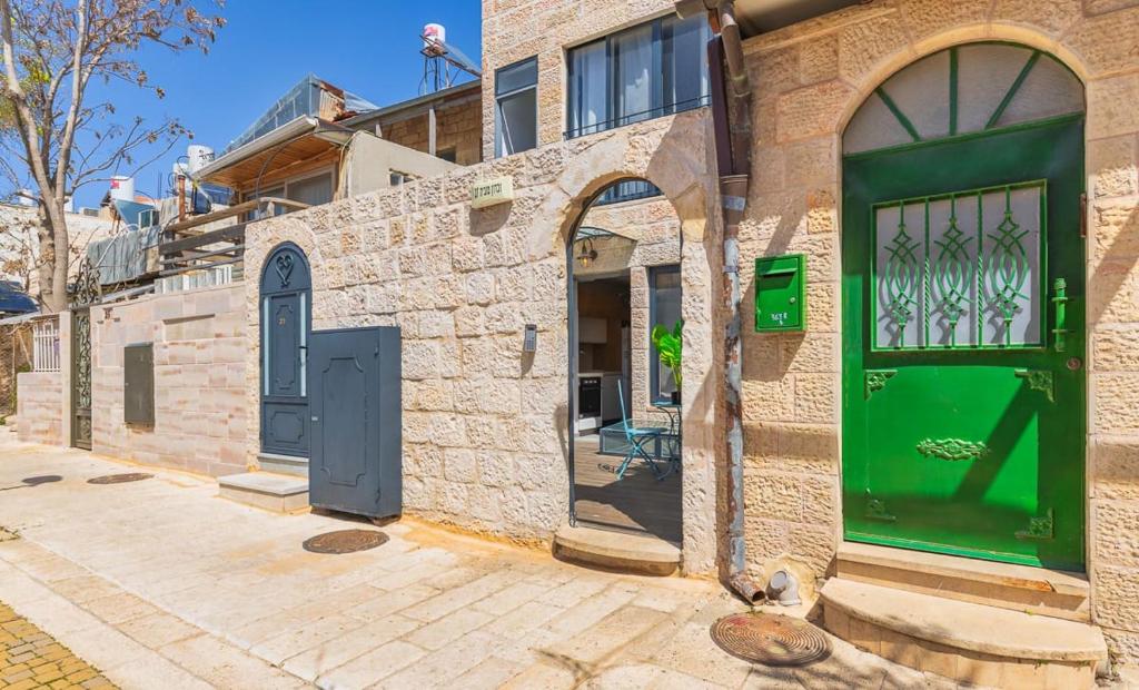 una puerta verde al lado de un edificio en Accommodation Apartments In The Heart Of The Nachlaot Neighborhood en Jerusalén