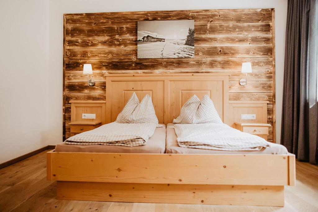 a bedroom with two beds and a wooden wall at Ferienwohnungen Wartbichler in Lofer