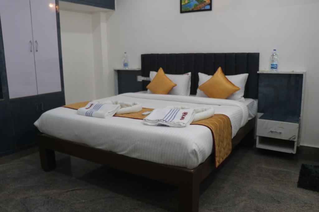 a bedroom with a large bed with two towels on it at Leo Home Stay in Tirupati
