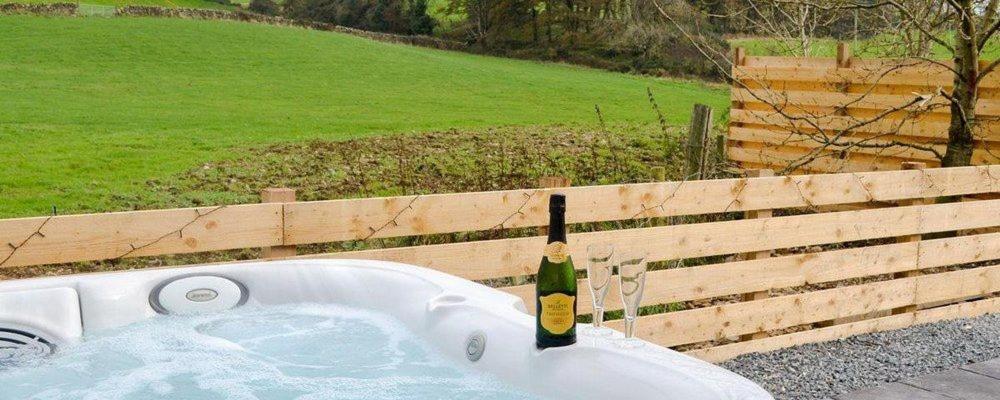 a white bath tub with a bottle of wine in it at Jack's Hideaway in Gatehouse of Fleet