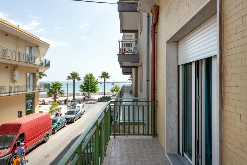 einen Balkon eines Gebäudes mit auf der Straße geparkt in der Unterkunft Appartamenti vista mare Otranto in Otranto