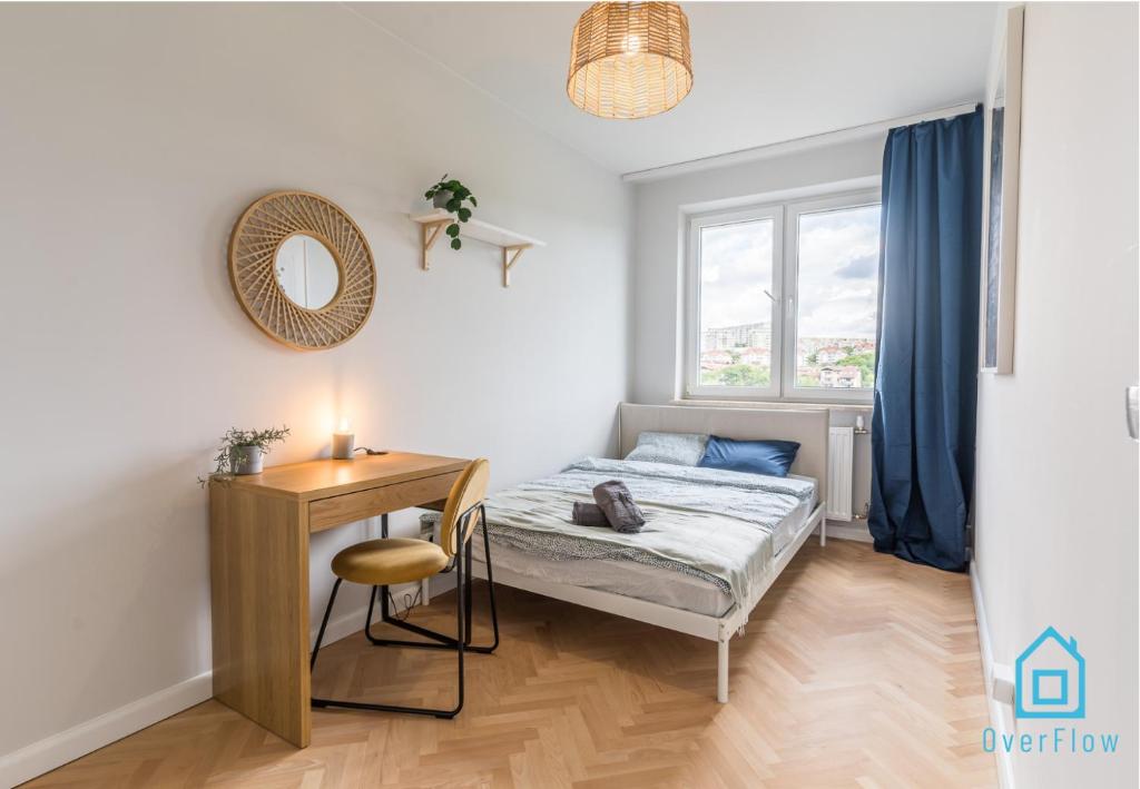 1 dormitorio con cama, mesa y ventana en Whizzy Room en Gdansk
