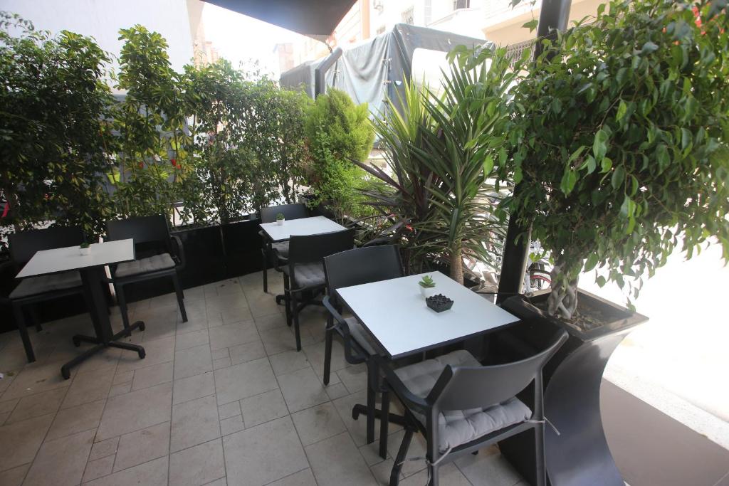 a patio with tables and chairs and potted plants at LOTUS HOTEL Casanearshore in Casablanca