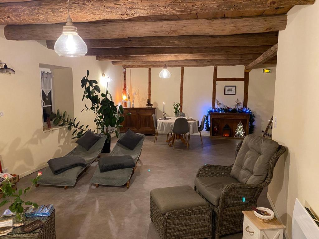 una gran sala de estar con sillas y mesa. en Suite privative sur Domaine Au chant de l'eau avec possibilité séjour bien-être, en Siaugues Ste Marie