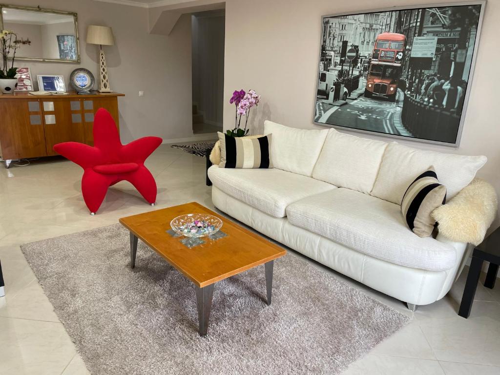 uma sala de estar com um sofá branco e uma estrela-do-mar vermelha em Casa da Grota em Porto Moniz
