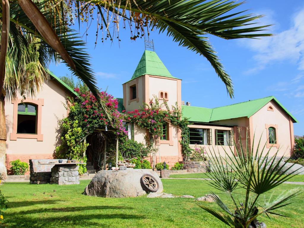 une église avec un toit vert et une tour d'horloge dans l'établissement Gondwana Canyon Lodge, à Kanebis