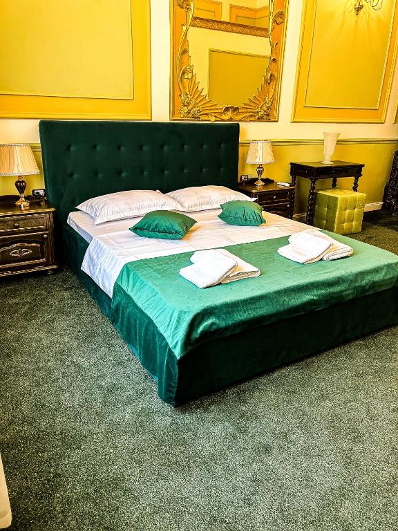 un grande letto verde con due cuscini verdi sopra di Hotel Boutique Casa Vermont a Bucarest