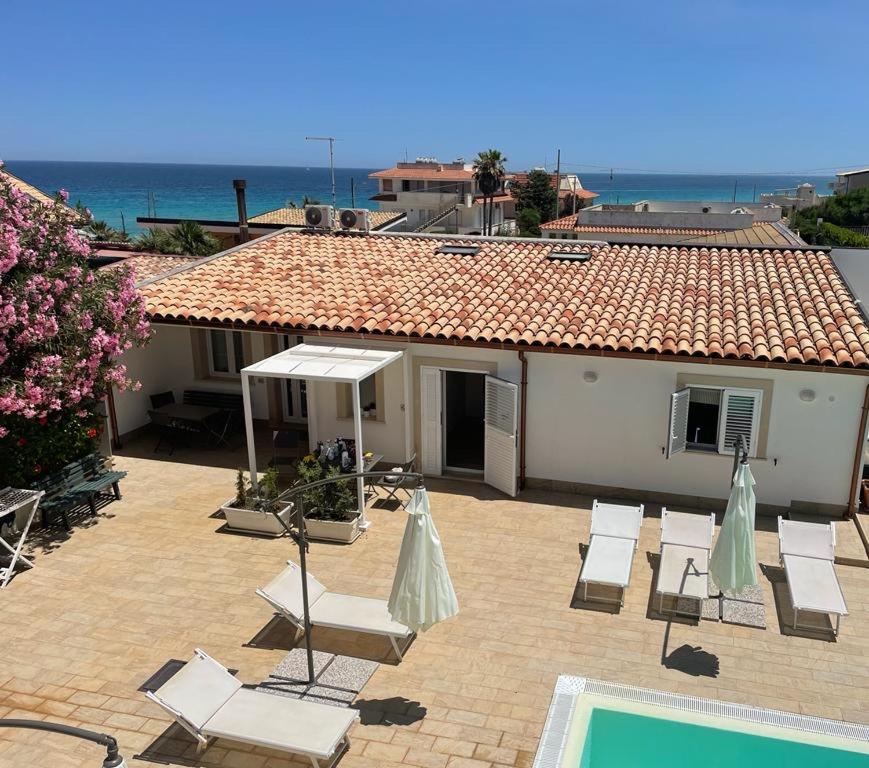 una casa con sillas, una piscina y un edificio en Archiammare Sea, en Reitani