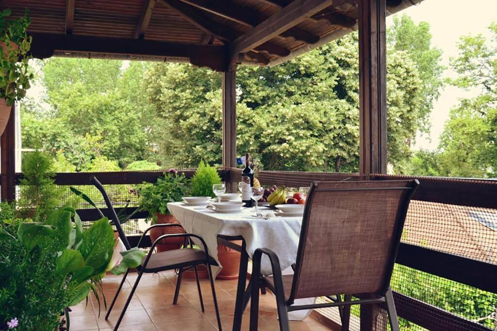 - une terrasse couverte avec une table et des chaises dans l'établissement Niki Apartments Sea View Attic, à Platamonas