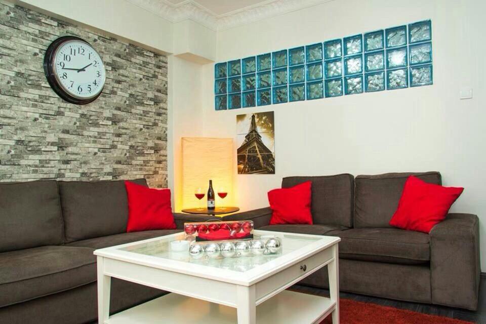 伊斯坦堡的住宿－Luxury Apartment in the center of Istanbul，客厅配有沙发和墙上的时钟