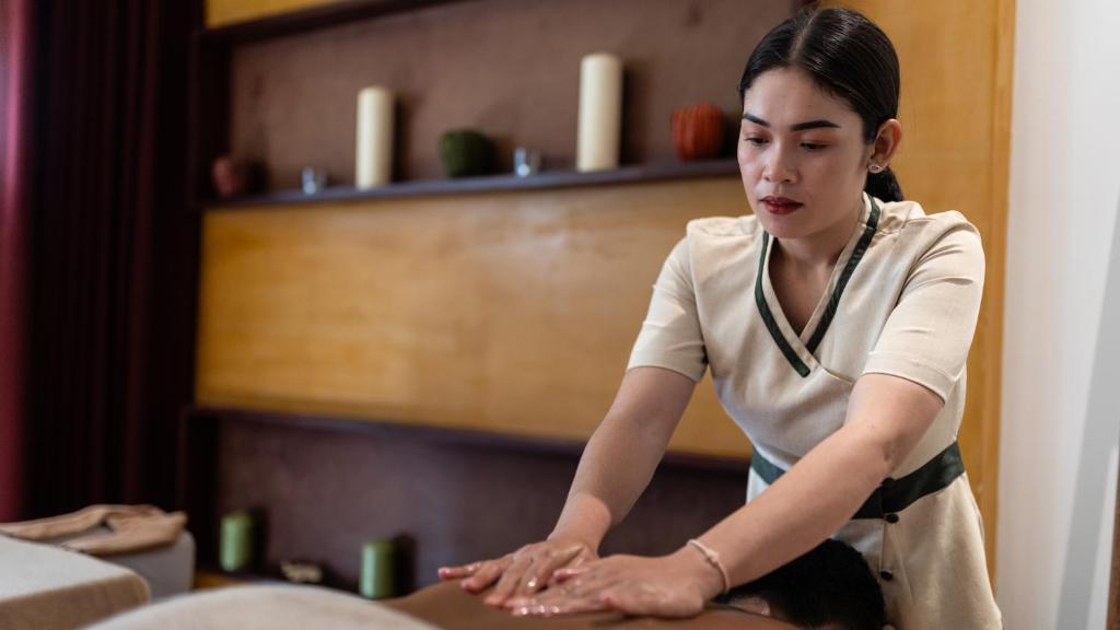 a woman sitting on a table in a room at Lynnaya Urban River Resort in Siem Reap