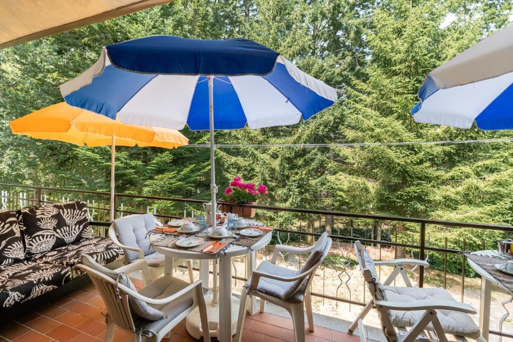 un patio con tavolo, sedie e ombrelloni di Appartamento Licia a Villa Basilica